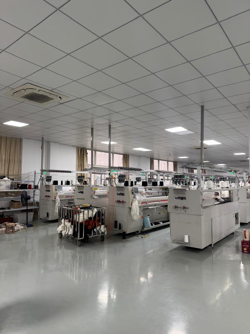 Knitting machine with fabric roll being produced