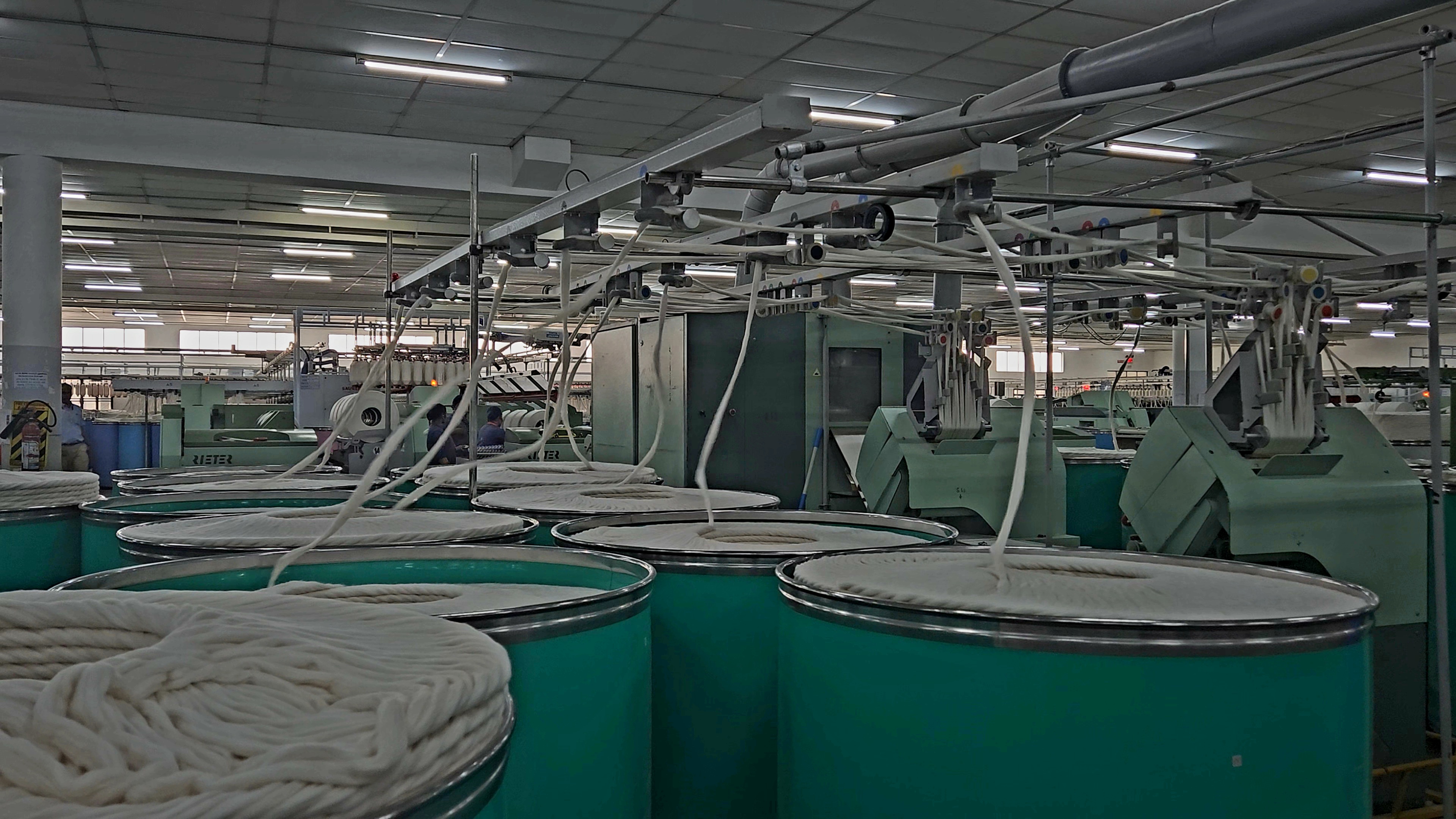 Rieter carding machines with sliver cans on factory floor