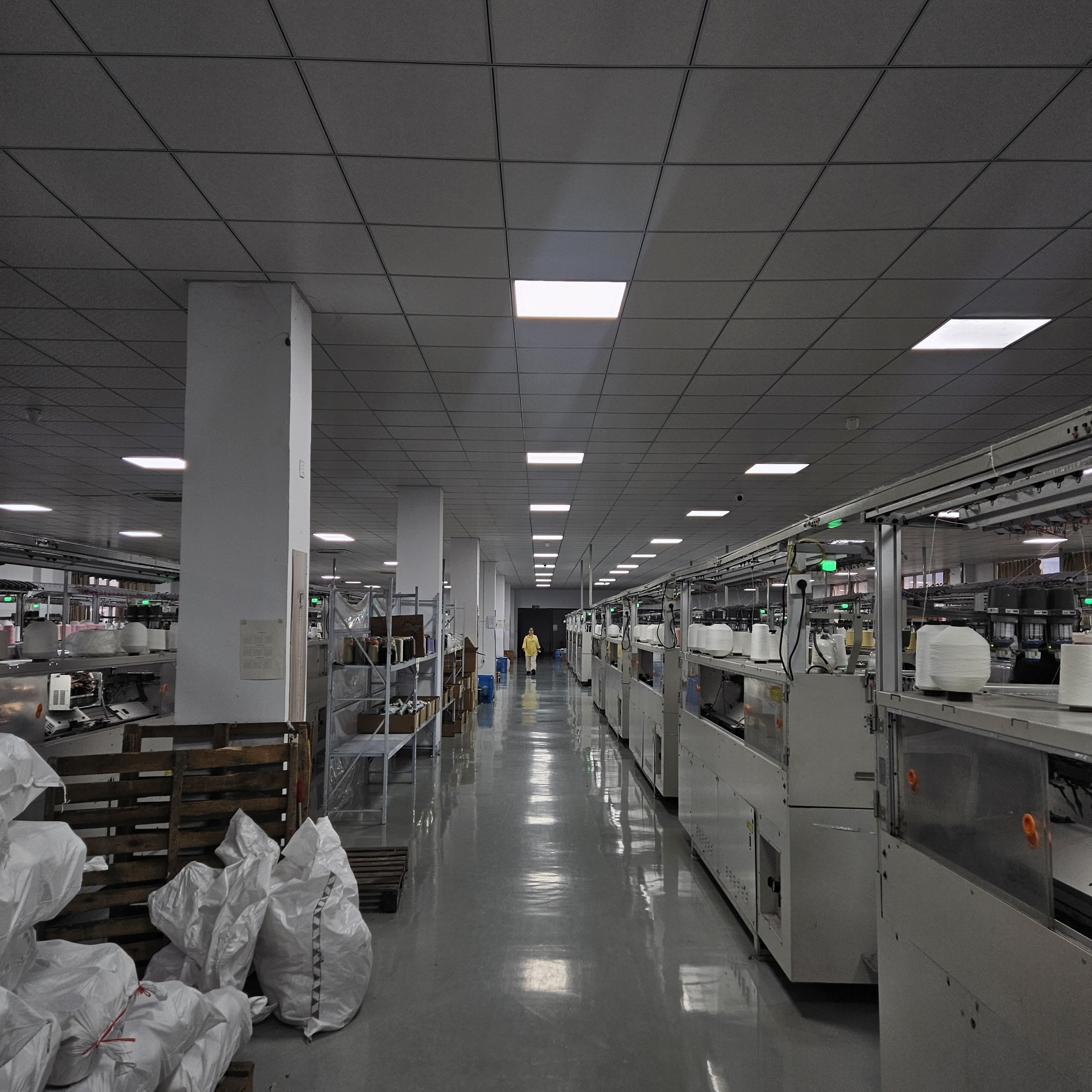 Yarn winding hall with worker walking between machines